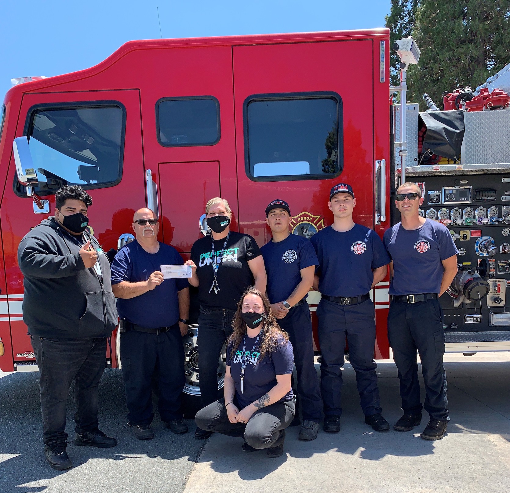 Photo of firefighters receiving a check from Perfect Union personnel.