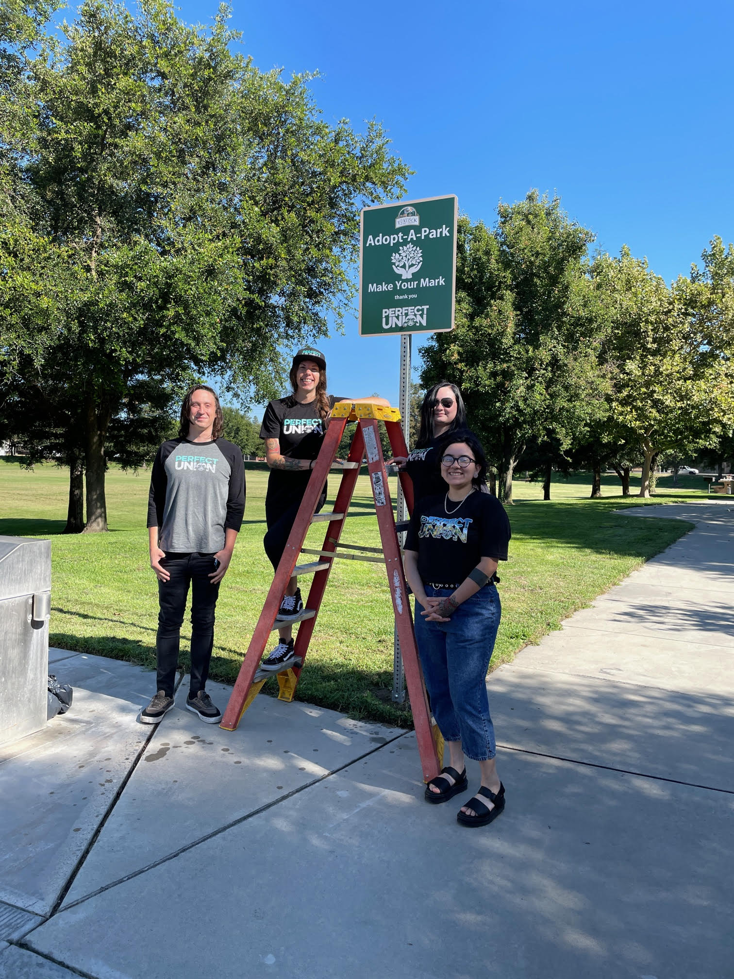 Photo of Perfect Union employees at Markley Park in front of the Adopt-A-Park sign.