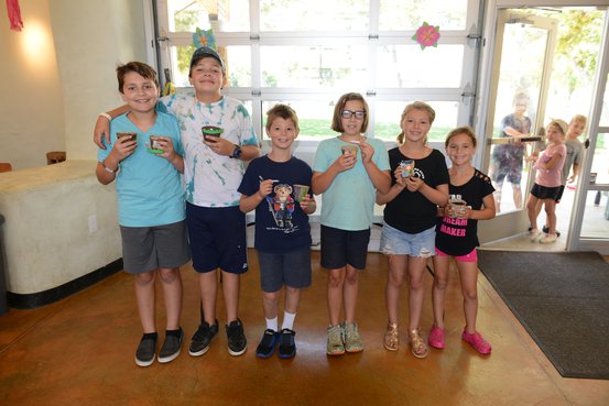 Photo of several kids standing together with snacks